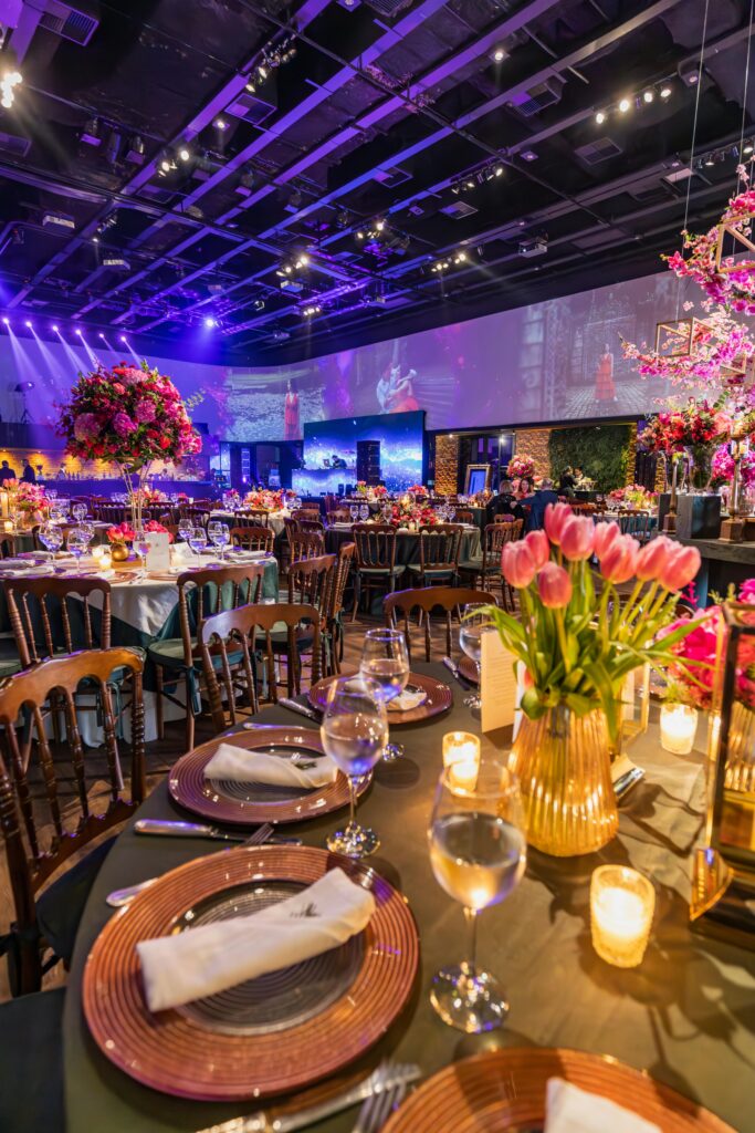 Luxurious event setup with flowers and candles creating an elegant atmosphere in a banquet hall.